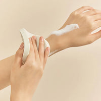 a woman's hands holding a white object with a lot of cream on it