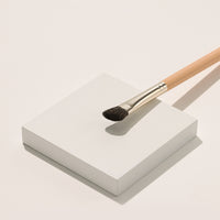 It features a tapered, slightly rounded brush head with soft, densely packed bristles that ensure accurate application and smooth blending.