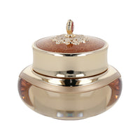 An elegant gold and red container featuring a flower, representing 'The history of whoo Cheonyuldan Hwayul Ultimate Regenerating Cream 60ml'.