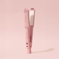 a pink electric toothbrush on a pink background