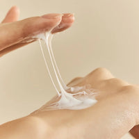 a woman's hand holding a white object in the air