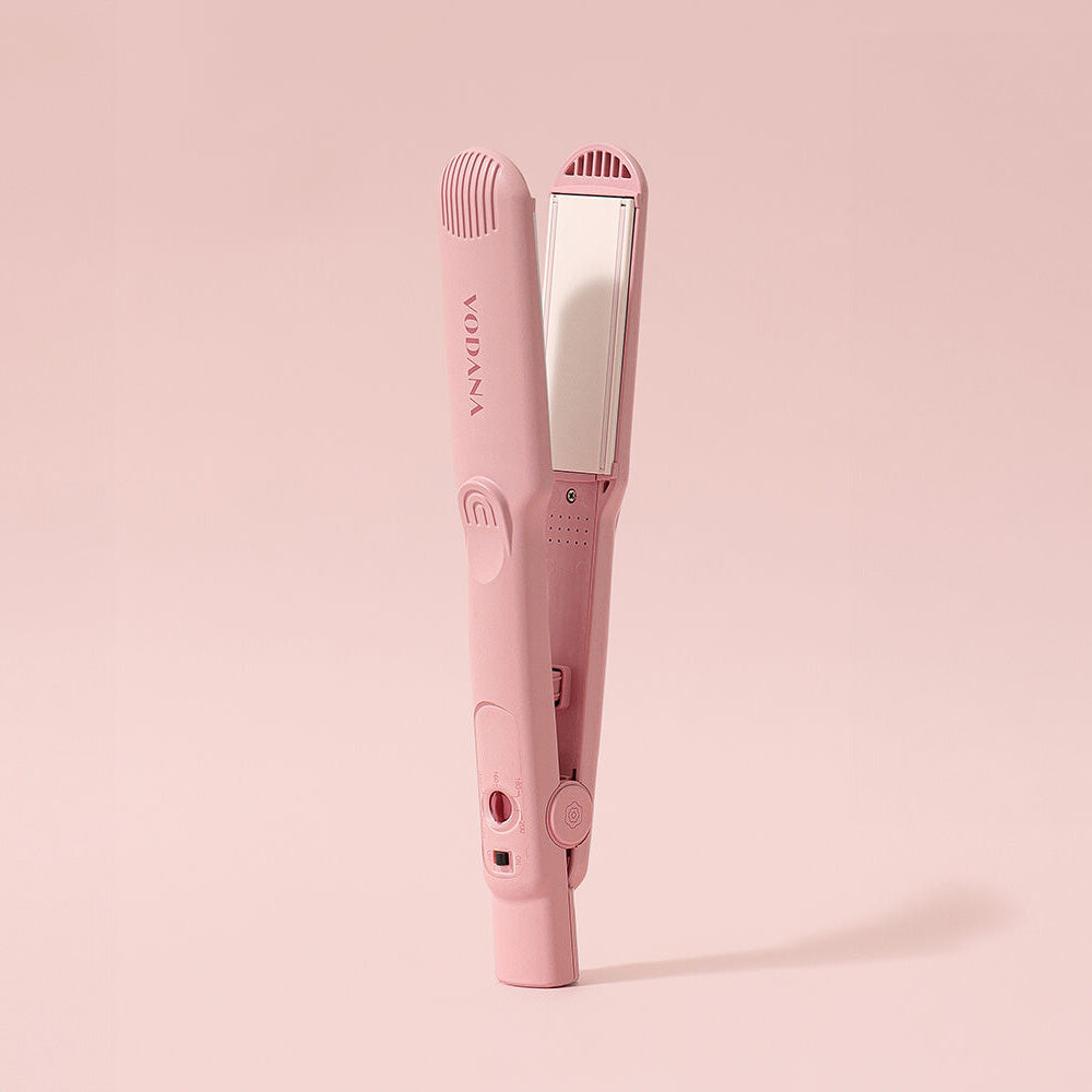 a pink electric toothbrush on a pink background